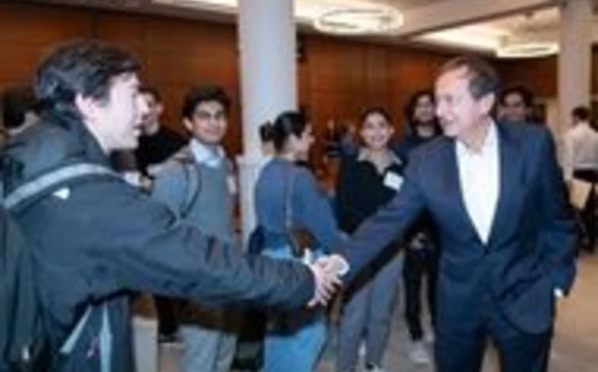 John Paulson shaking a student's hand