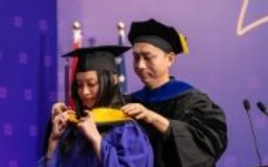 A student graduating and a faculty member