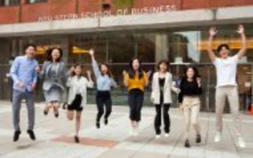 Students are pictured jumping after the NYU Stern and NYU Shanghai orientation. 