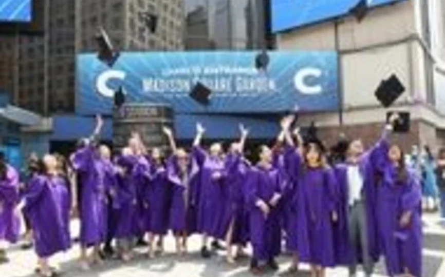Student throw their cap in the air outside of MSG before graduation.