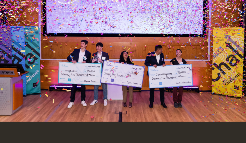 winners of the entrepreneurs challenge holding prize checks with confetti falling down