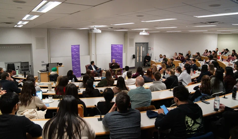 a room of people listen as Dickerson speaks