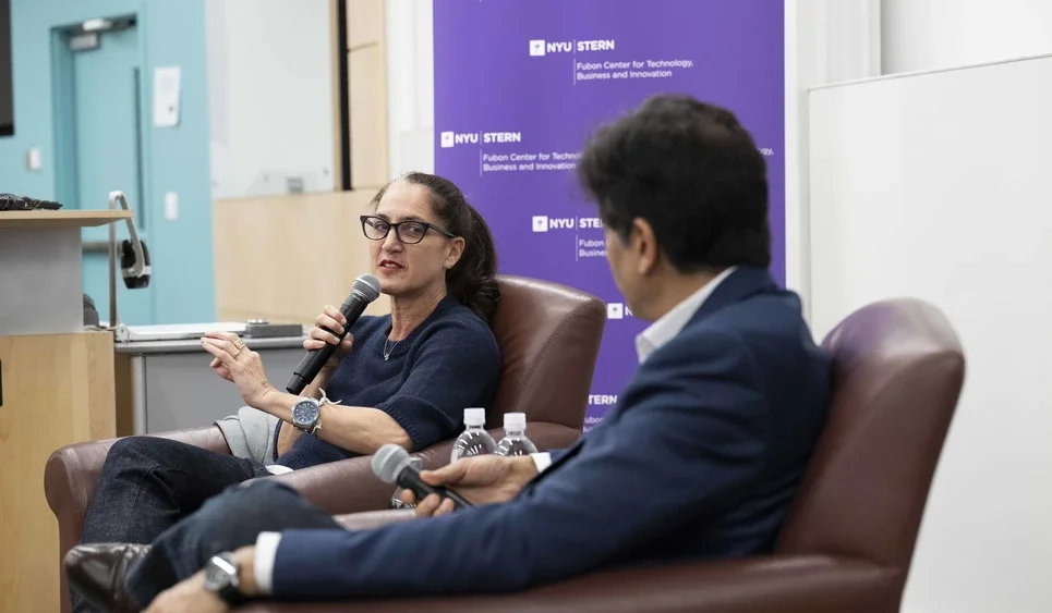 Landsman holds a microphone and speaks with Sundararajan