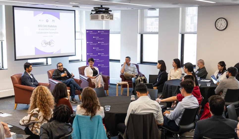 four panelists sit in chairs and speak to the audience