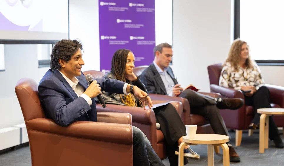 four speakers sit in chairs for panel discussion