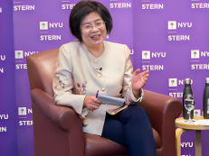 Peggy Yu sitting in a chair giving a speech