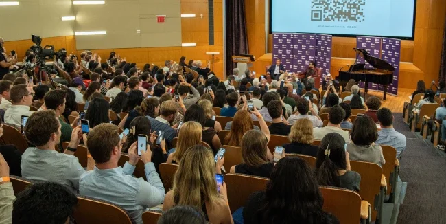 A crowd of students watching Dean Anand and A R Rahman in conversation in an auditorium