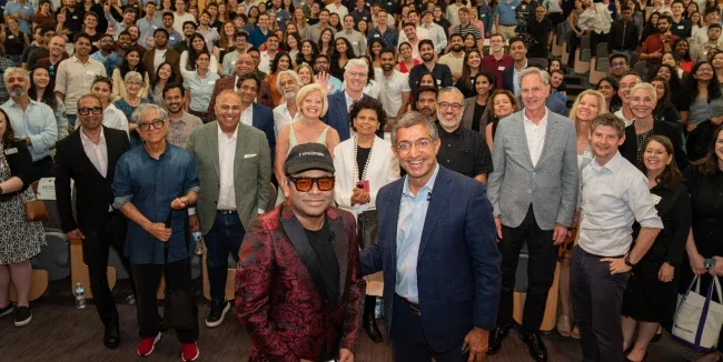 Crowd standing in auditorium with A R Rahman and Dean Anand in front