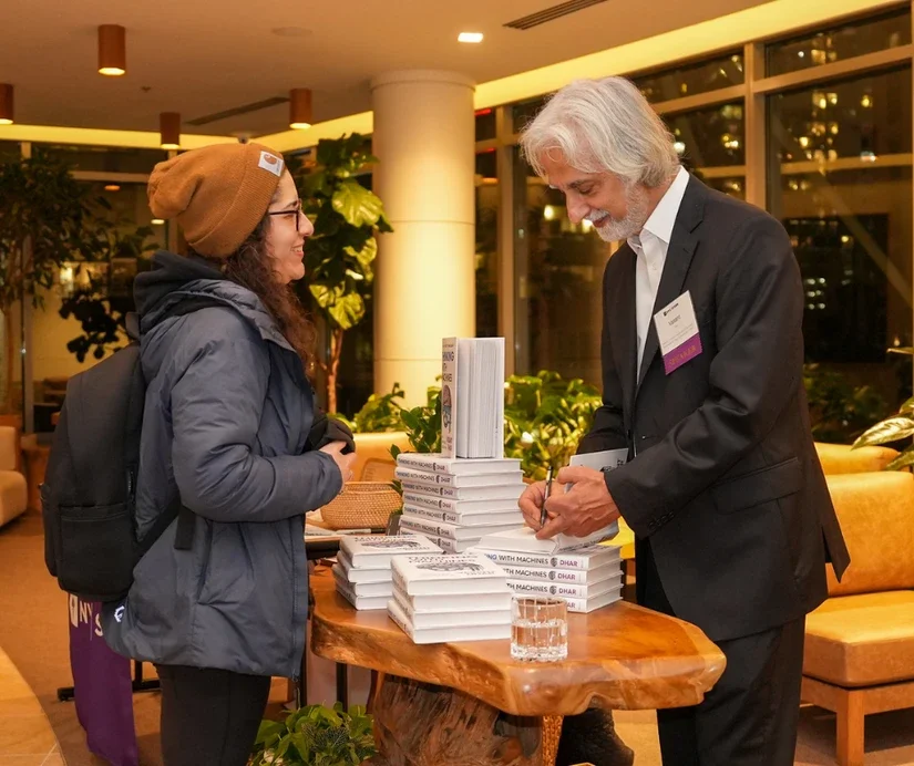 Professor Vasant Dhar signing books and mingling with alumni