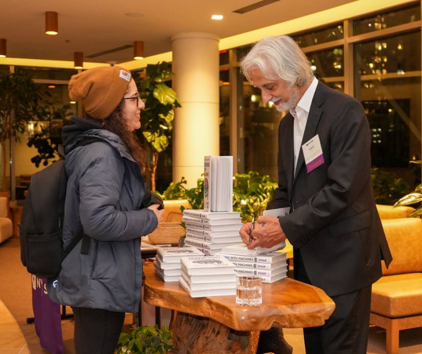 Professor Vasant Dhar signing books and mingling with alumni