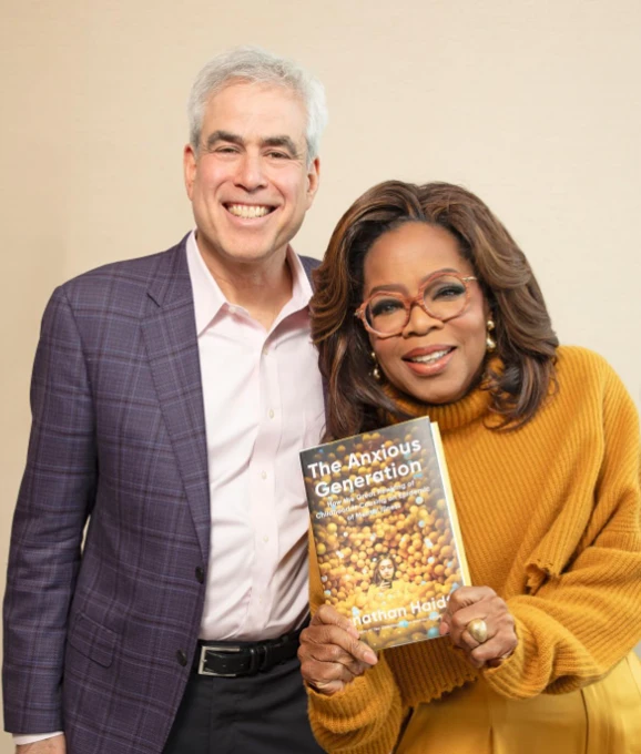 Jonathan Haidt with Oprah Winfrey and his book The Anxious Generation