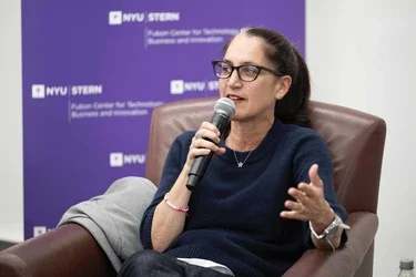 Liza Landsman holds a microphone and speaks